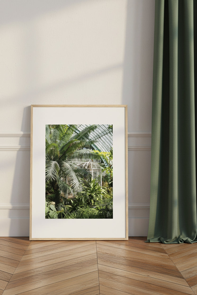Une œuvre lumineuse mêlant feuillages tropicaux et structure de serre élégante.